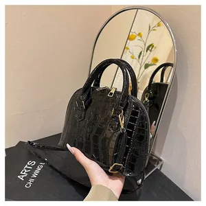 Detailed mirror view showing the glossy black crocodile pattern on this shell handbag