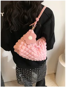 Détail du sac rose à texture bulle avec breloque fleur et anneau métallique doré élégant