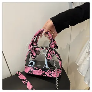 Dettaglio di rifiniture in pitone rosa e nero e cerniere sulla borsa in PVC trasparente