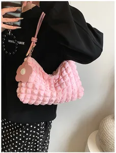 Détail du sac à bandoulière en tissu bouffant rose avec charm fleur et texture