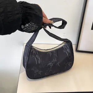 Detail of black nylon underarm bag with bamboo leaf print and sturdy zipper closure