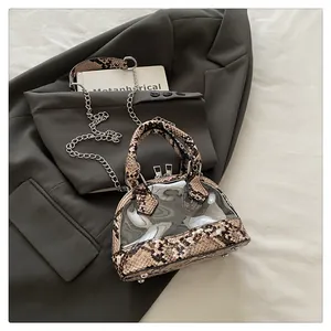 Dettaglio borsa a conchiglia in PVC con finiture a serpente e catena in argento