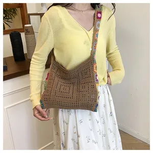 Détail du sac bandoulière au crochet avec motifs floraux colorés et texture tissée marron