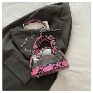 Dettaglio del bordo rosa pitonato e PVC trasparente su una borsa a conchiglia