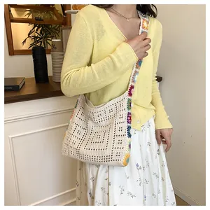 Détail du sac à bandoulière en maille avec sangle brodée de fleurs sur tenue décontractée