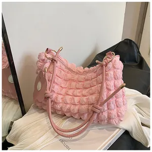 Détail du sac cabas rose en tissu gaufré avec bandoulière et breloque fleurie