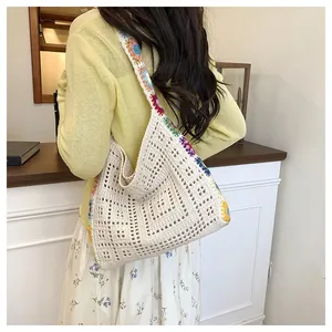 Détail d'un sac cabas bohème au crochet avec fleurs brodées et texture tricotée