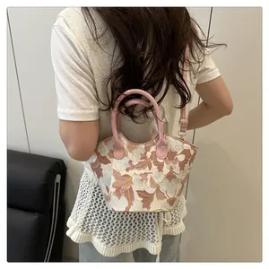 Detail of floral embroidered handbag showing exquisite stitching and pink crossbody strap