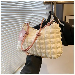 Détail du sac à main blanc texturé popcorn avec anse rose et charm fleur décorative