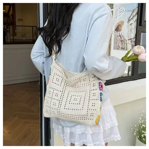 Détail d'un sac au crochet avec fleurs faites main et motifs géométriques ajourés