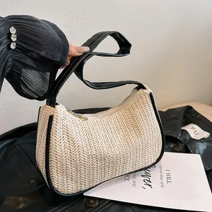 Chic woven underarm bag in beige straw style with black leather strap and trim accents