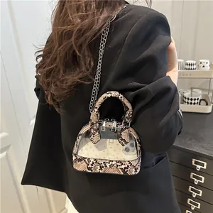 Elegante borsa a conchiglia in PVC a serpente con catena d'argento indossata da modella