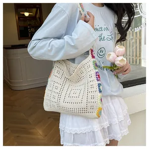 Détail d'un sac cabas en crochet fait main avec broderies florales colorées et élégantes