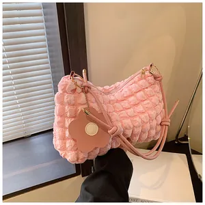 Détail du tissu gaufré rose du sac à fleurs avec bandoulière à nœuds et pendentif