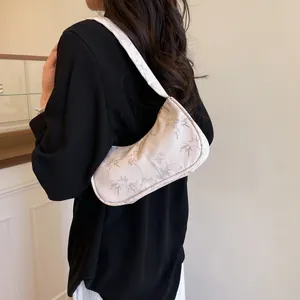 Detail view of crescent hobo bag with elegant grey bamboo leaf patterns on cream fabric