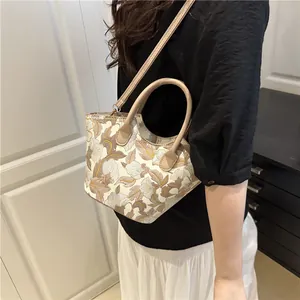 Elegant embroidered floral handbag with dual handles and crossbody strap in cream white finish