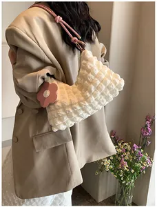Détail du sac cabas blanc à texture bulles avec bandoulière rose et breloque fleurie