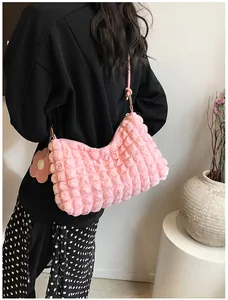 Détail du sac cylindre rose à texture bulles avec breloque fleur et boucle dorée
