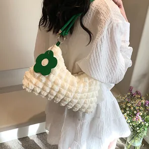 Sac cylindrique blanc à texture bulles avec bandoulière verte et pendentif floral