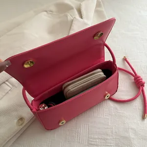 Hot pink leather bow shoulder bag with magnetic closure and organized interior view