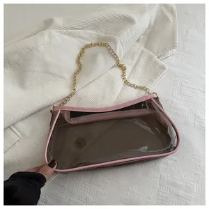 Détail du sac bandoulière transparent en PVC avec liseré rose et chaîne en métal doré