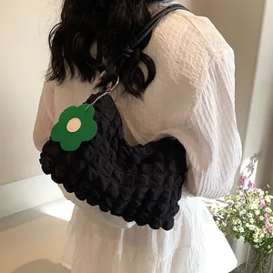 Sac fourre-tout noir à texture bulle avec charme fleur verte porté par un mannequin
