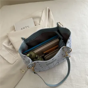 Light blue quilted tote bag with large capacity showing spacious interior and items