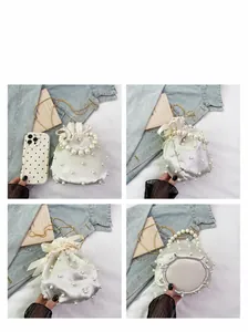 Detailansicht der weißen Perlen-Beuteltasche mit Satin-Finish und Goldkette