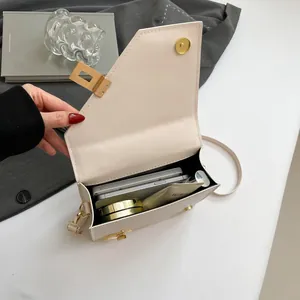 Beige asymmetric saddle crossbody bag showing spacious interior with elegant gold hardware