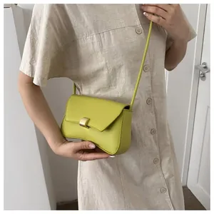 Close-up of lime green baguette bag featuring a gold buckle and textured leather surface