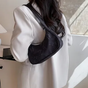 Close-up of black nylon hobo bag with bamboo leaf pattern on a model shoulder