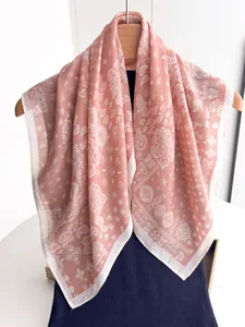 Close-up of pink cotton linen scarf with white paisley patterns on wooden hanger