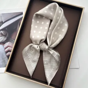 Champagne polka dot faux silk scarf tied in a bow inside a premium gold-trimmed gift box