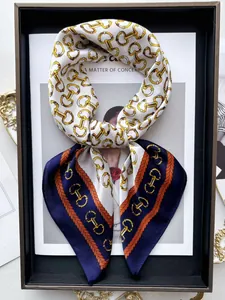 Dettaglio foulard in seta bicolore con stampa morsetto e catena in cornice nera