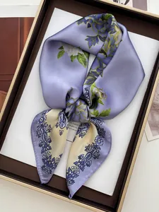 Détail du foulard en soie à fleurs violettes et jaunes dans son coffret cadeau chic