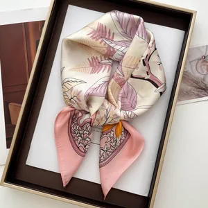 Dettaglio di un foulard di seta rosa con stampe botaniche in una scatola da esposizione