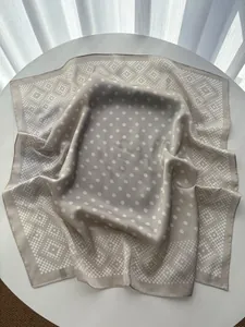 Detailed texture of champagne silk scarf with polka dot patterns and refined edges