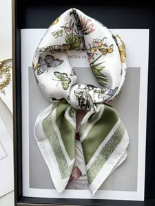 Dettaglio di sciarpa in seta con strisce verdi e motivi di fiori e farfalle