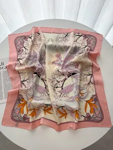 Dettaglio di un foulard di seta con stampa floreale che mostra bordi rosa e trama