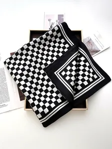 Flat lay of black and white checkerboard silk scarf with decorative magazine cards