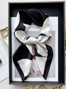 Dettaglio di un foulard in seta geometrico piegato su una rivista di moda elegante