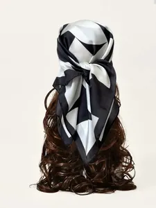 Dettaglio foulard in seta bianco e nero con motivi geometrici indossato come fascia