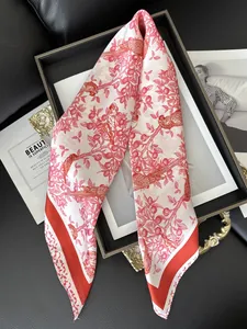Detail of red floral silk scarf with bird pattern and red border on black texture