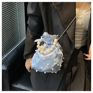 Detail der hellblauen Satin-Beuteltasche mit weißen Perlen, Seidenschleife und Kette