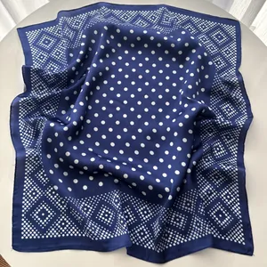 Detail of navy blue square scarf with white polka dots and geometric diamond patterns