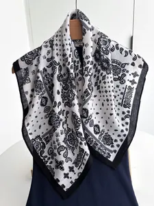 Close-up of black and white paisley cotton linen scarf hanging on a wooden hanger