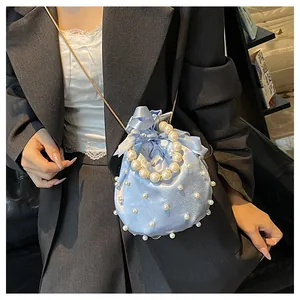 Detail der hellblauen Satin-Beuteltasche mit Perlenverzierung und Kettenriemen