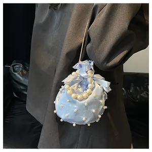 Details der hellblauen Satin-Beuteltasche mit eleganten Perlen und Seidenbandschleife