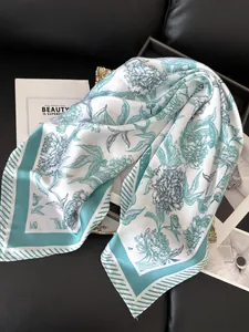 Detail of elegant floral silk-like scarf with peony pattern and striped borders
