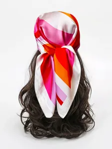 Dettaglio di un foulard di seta a righe colorate legato tra i capelli effetto satin